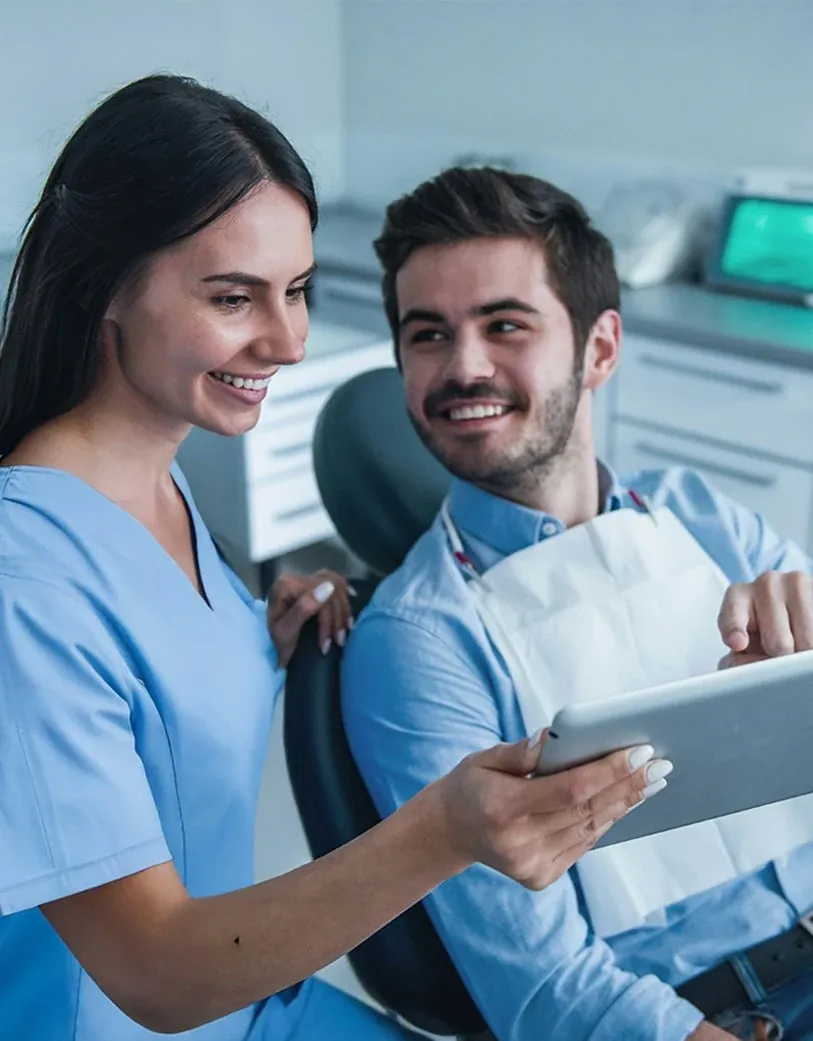 A patient smiling at her dentist from the chair at The Smile Center.