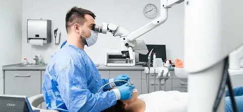 A dentist at the microscope in the surgery at The Smile Center.